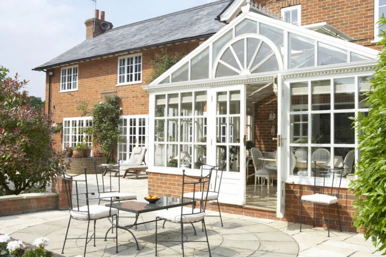 Glass conservatory adjoining a brick house