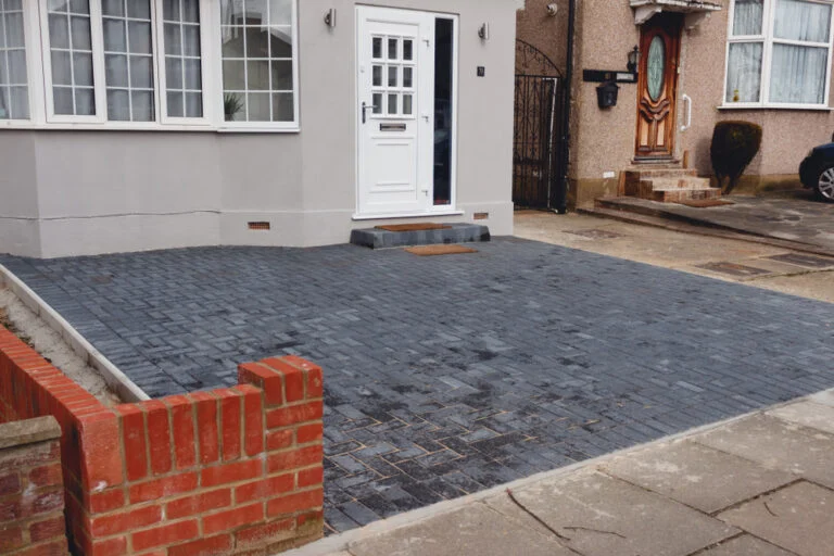 Block-paved driveway beside a brick house