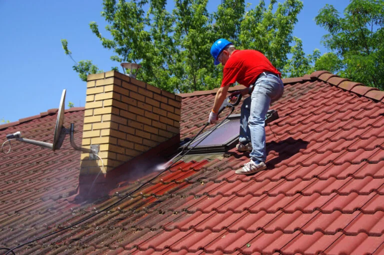 Cleaning a red tiled roof with a washing lance