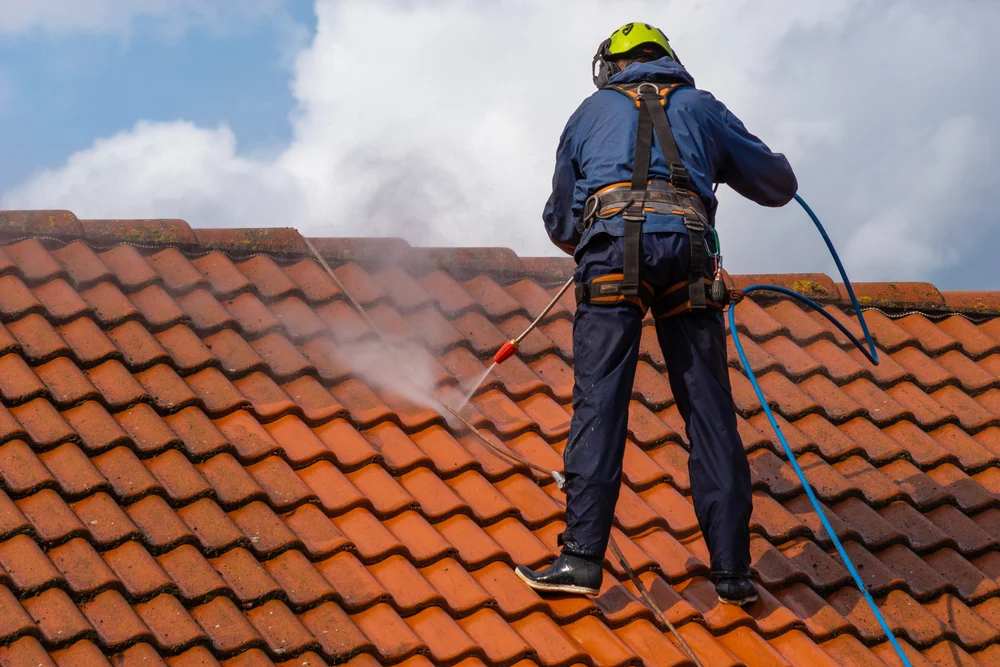 Cleaning a red tiled roof with a washing lance