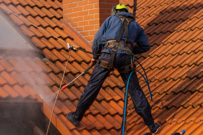 Cleaning a red tiled roof with a washing lance