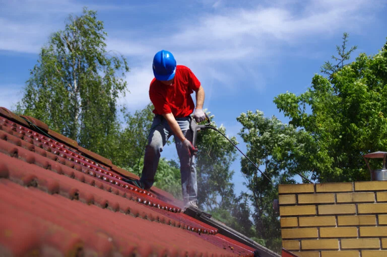 Cleaning a red tiled roof with a washing lance