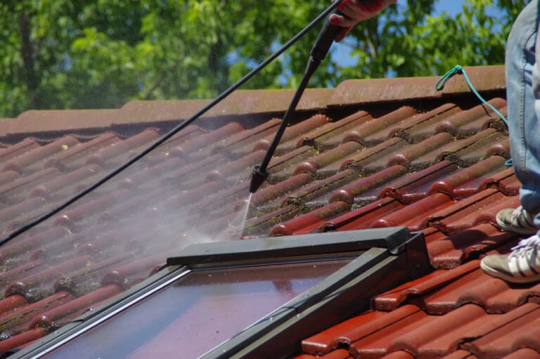 Cleaning a red tiled roof with a washing lance