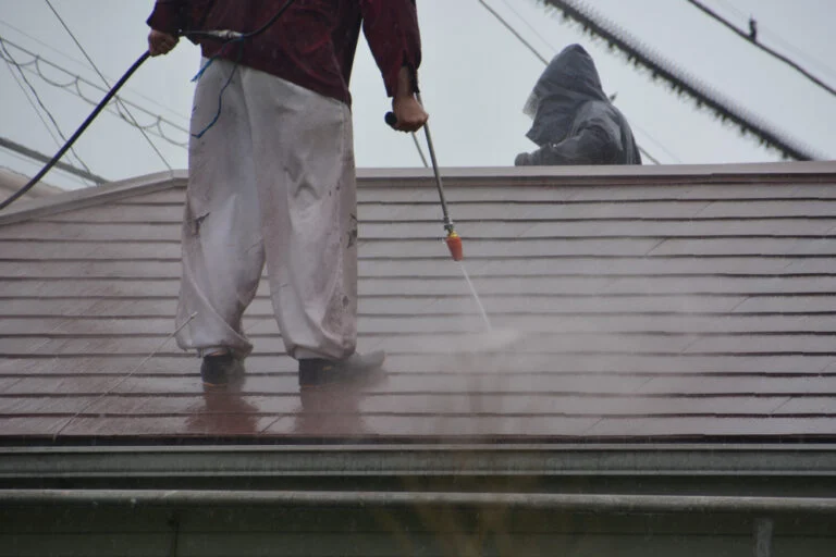 Cleaning a red tiled roof with a washing lance