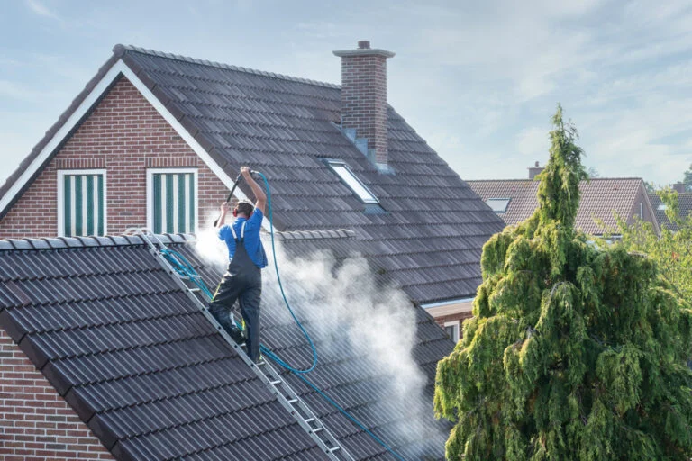 Worker washing a tiled roof