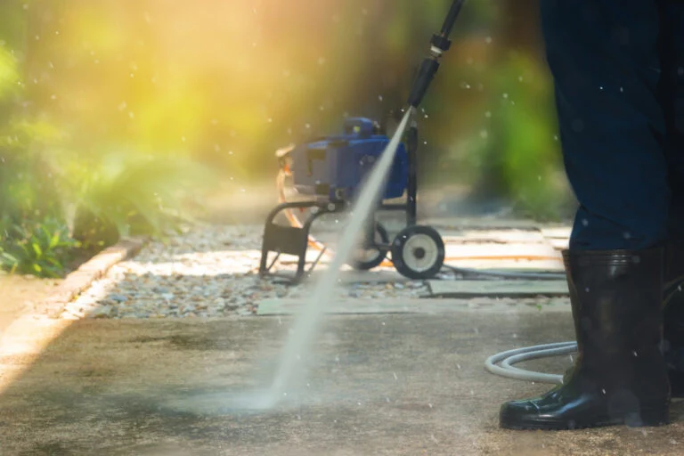 Worker using a surface cleaner on paving