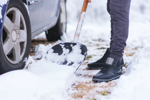 Snow and debris beside a parked car