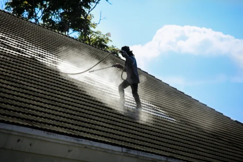 Cleaning a red tiled roof with a washing lance