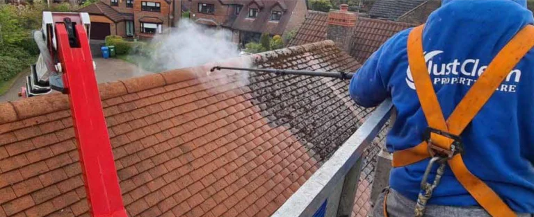 Cleaning a red tiled roof with a washing lance