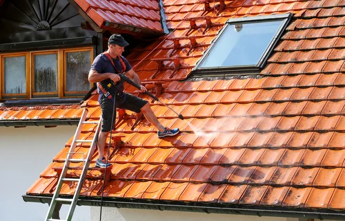 Cleaning a red tiled roof with a washing lance