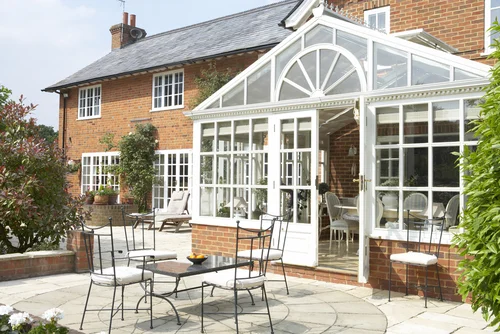 Glass conservatory adjoining a brick house