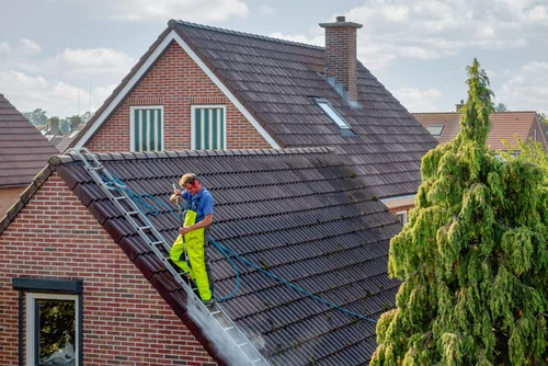 Cleaning a red tiled roof with a washing lance