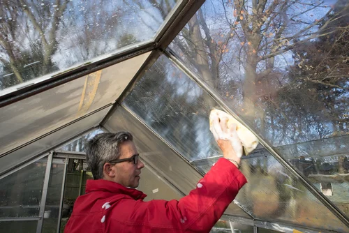 Worker cleaning a conservatory roof
