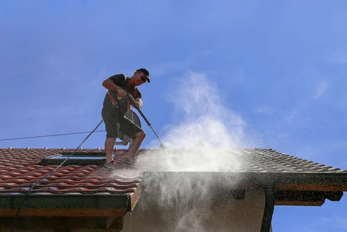 Cleaning a red tiled roof with a washing lance