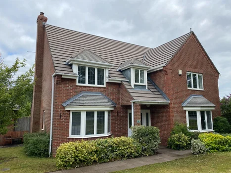 Detached brick house with a cleaned tiled roof