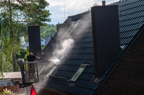Cleaning a red tiled roof with a washing lance