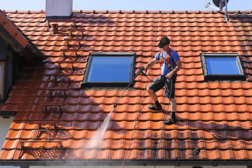 Cleaning a red tiled roof with a washing lance