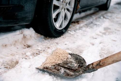 Snow and debris beside a parked car