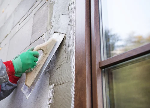 Worker washing the outside wall of a building