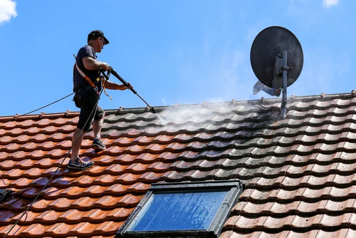 Cleaning a red tiled roof with a washing lance