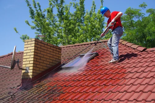Cleaning a red tiled roof with a washing lance
