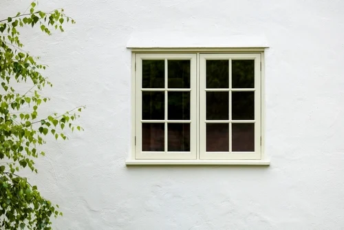 Light-coloured rendered wall beside a lawn