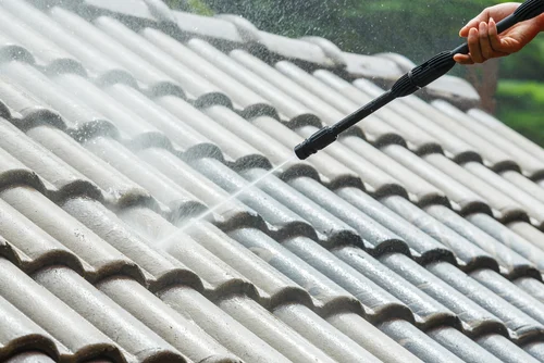 Worker cleaning roof tiles