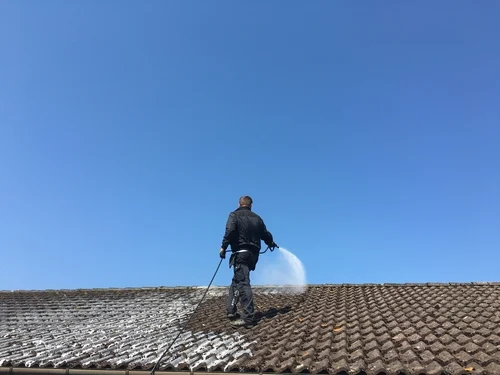 Cleaning a red tiled roof with a washing lance