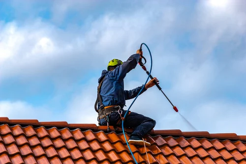 Cleaning a red tiled roof with a washing lance