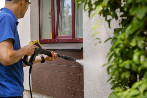 Worker washing the outside wall of a building
