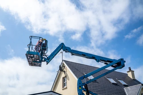 Worker accessing a roof from a raised platform