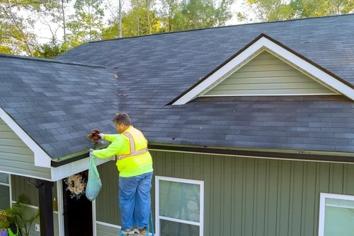 Worker pressure washing an exterior paved area