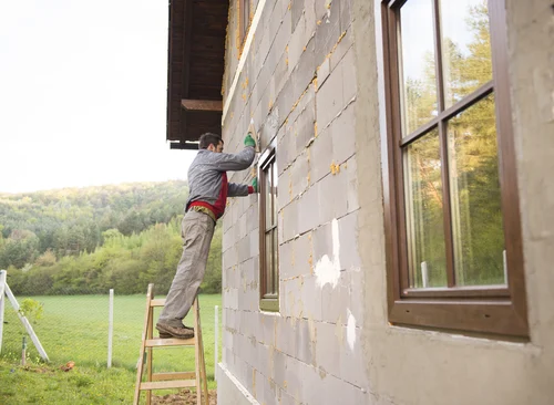Worker washing the outside wall of a building