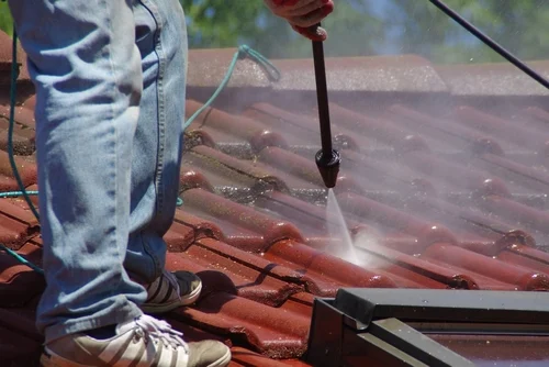 Cleaning a red tiled roof with a washing lance
