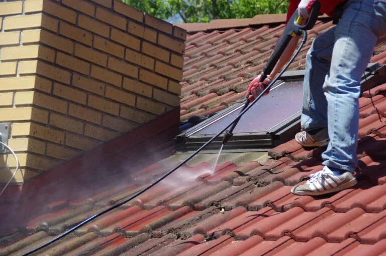 Cleaning a red tiled roof with a washing lance