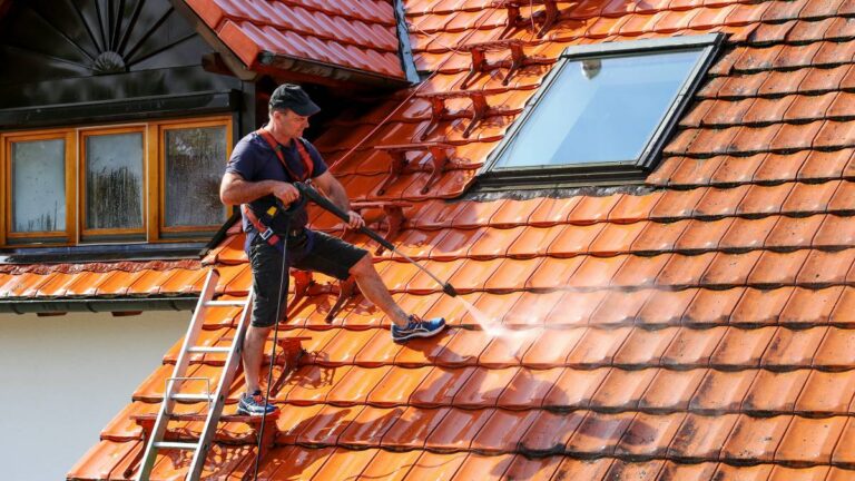 Cleaning a red tiled roof with a washing lance