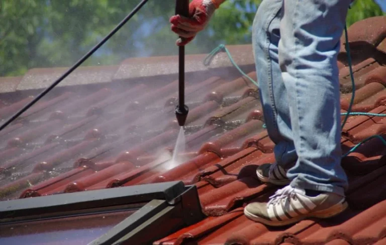 Cleaning a red tiled roof with a washing lance