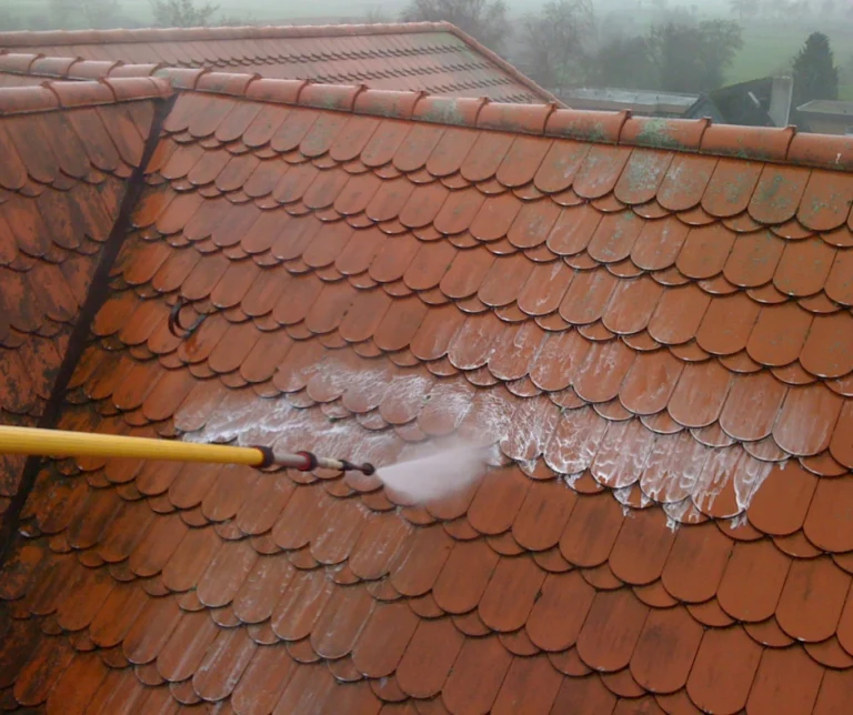 Cleaning a red tiled roof with a washing lance