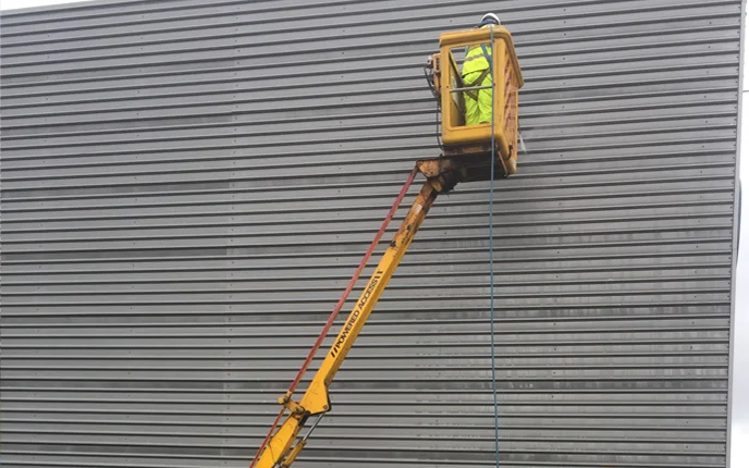 Commercial cladding being cleaned from an elevated platform