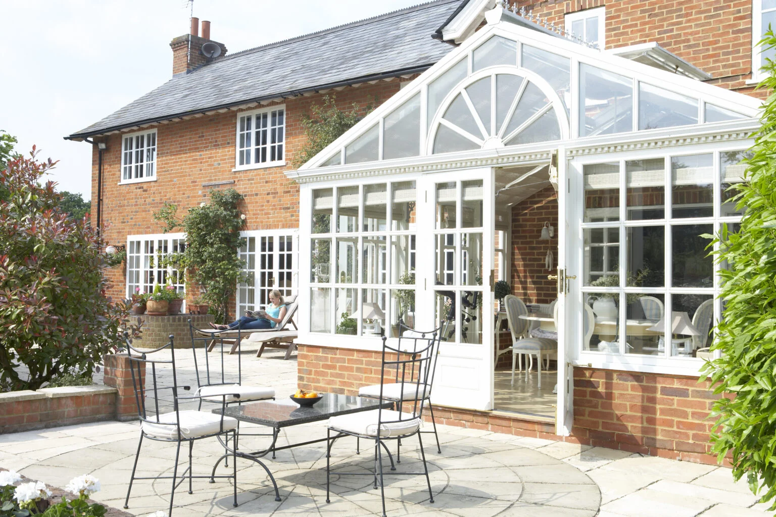 Glass conservatory beside a brick home